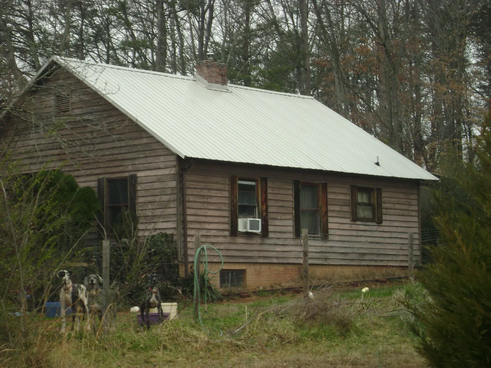 White metal roof on an old wood sided farmhouse, from a Asphalt Shingle Roof Repair job in Salina